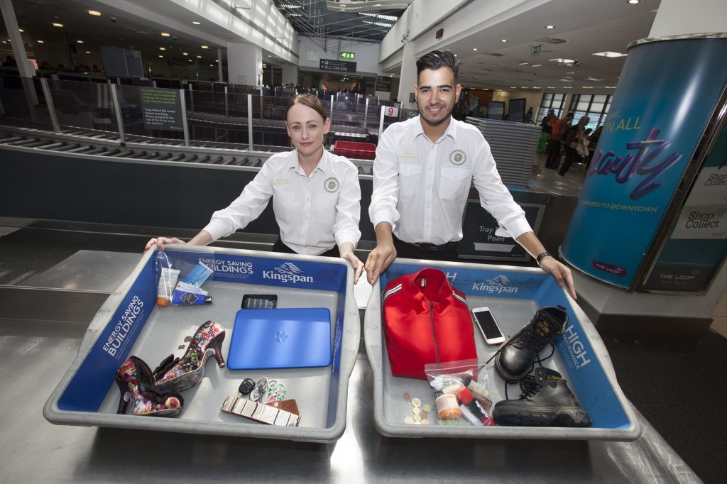 Airport Security Screening Officers, Michelle Halpin and Sergio Rocha with a sample of what passengers should place in the trays at security screening. Photo: Dublin Airport